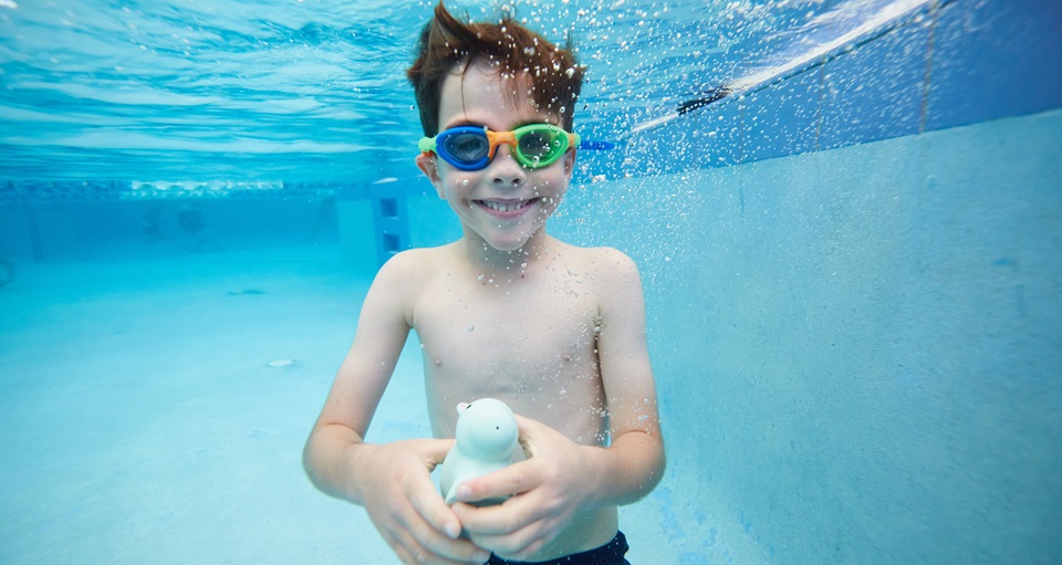 Underwater view of young boy smiling at the camera